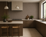 A modern kitchen interior with dark wood cabinetry, a textured brown tile backsplash, a light stone countertop, and two pendant lights hanging above a central island with two bar stools.