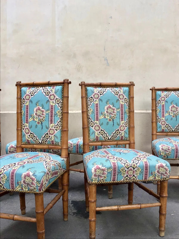 Three matching upholstered dining chairs with bamboo-style frames and turquoise floral patterned fabric, photographed against a plain beige wall. Callista Home