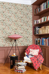 Room interior with floral wallpaper, bookshelf, and armchair with a pink cover.