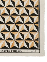 A close-up of a printed textile or paper product showing a repeating geometric cube-like pattern in black, off-white, and light tan woodgrain, with the text 'DINETTE POISSON. - N°5' along the bottom edge. Calista Home