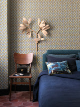 Cozy bedroom with blue bedding, patterned wallpaper, and a wooden chair. Callista Home
