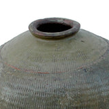 Close-up of a large textured ceramic vase or amphora with a conical neck and dark opening, shown against a plain white background.