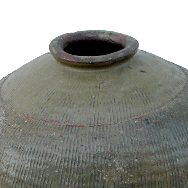 Close-up of a large textured ceramic vase or amphora with a conical neck and dark opening, shown against a plain white background.