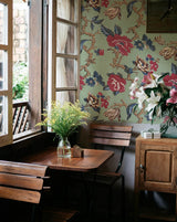 Dining area with wooden table, chairs, and floral wallpaper.