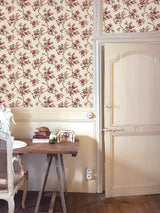 Floral wallpaper with a wooden table and chair in a room.