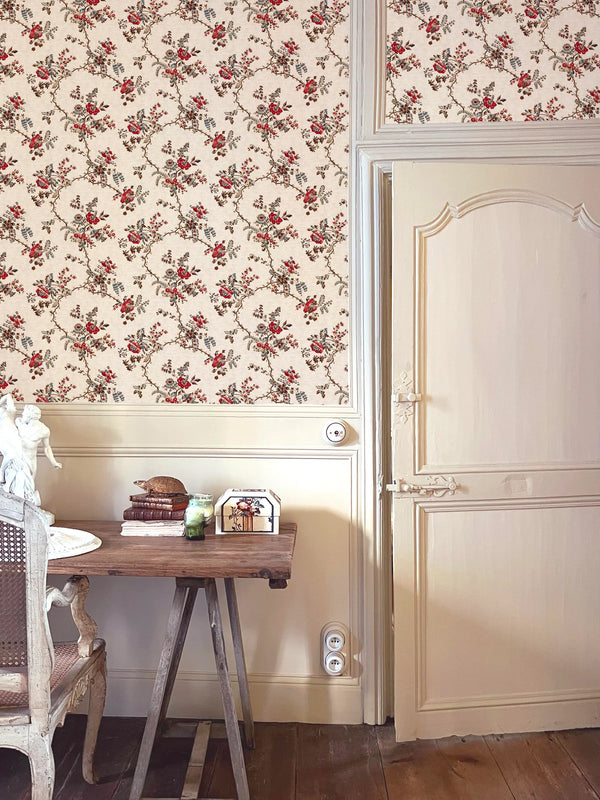 Floral wallpaper with a wooden table and chair in a room.