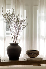 Decorative vase with branches on a table in a bright room