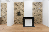 A styled interior room with three patterned wallpaper panels on the walls, a black marble fireplace mantel, light wood floors, and white columns.