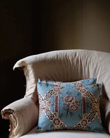 Decorative pillow with floral pattern on a beige armchair against a dark Callista Home background