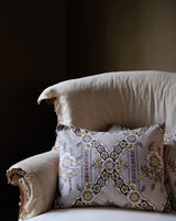 Decorative pillow with floral patterns on a chair against a dark background Callista Home