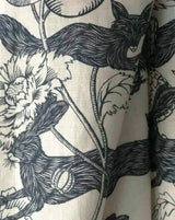 A close-up of a fabric or wallpaper pattern featuring black line-art illustrations of foxes and wildflowers on an off-white background. Callista Home